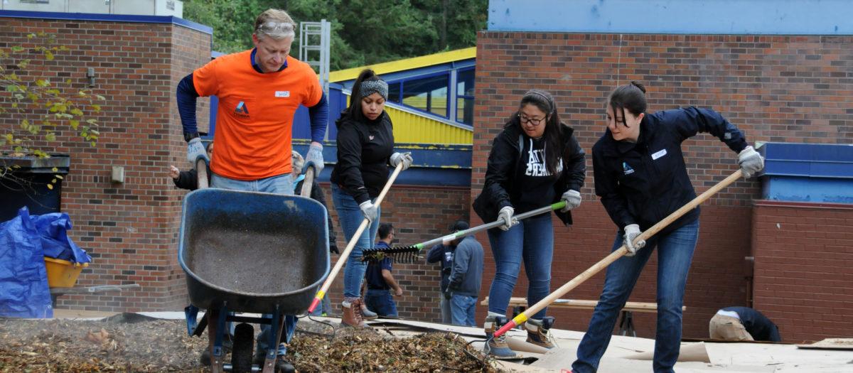A group of 4 people work to construct a rain garden at a school